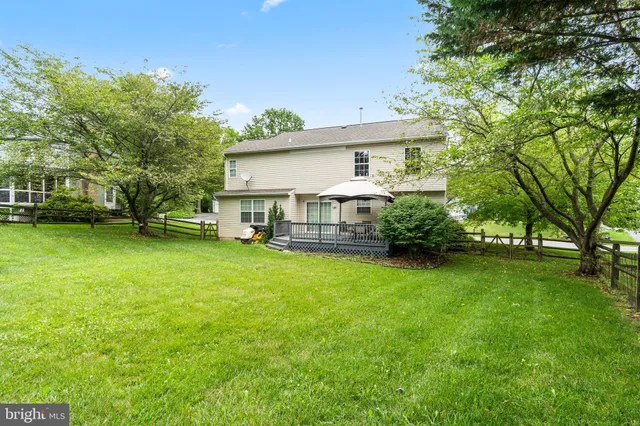 a view of a house with backyard and a tree