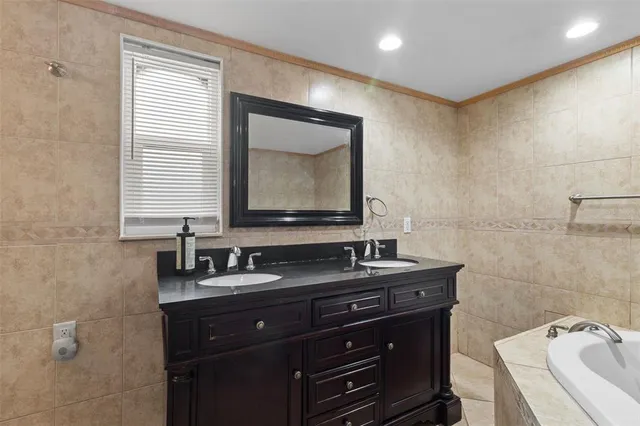a bathroom with a granite countertop sink toilet mirror and bathtub