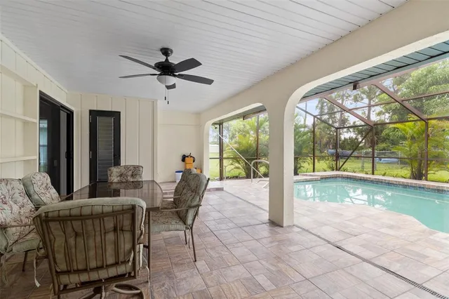 a view of a backyard with table and chairs under an umbrella with a small yard