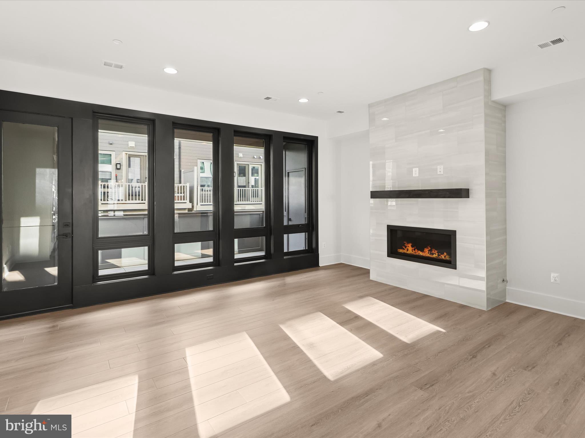 14920 Dispatch Street Rockville, MD 20850 - Photo 12 of 85 a view of an empty room with a fireplace and a window