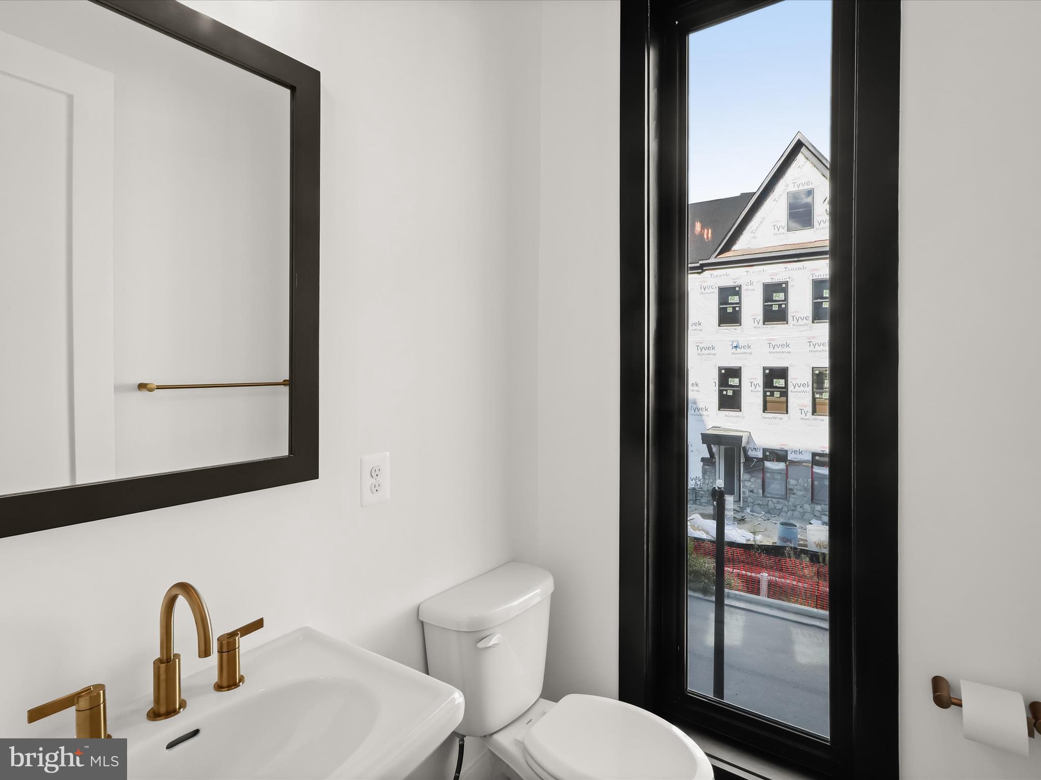 14920 Dispatch Street Rockville, MD 20850 - Photo 31 of 85 a bathroom with a toilet a sink and mirror