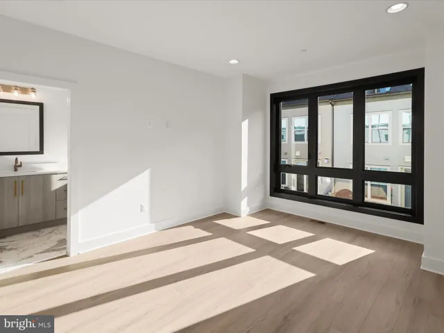 a view of an empty room with chandelier fan and fire place