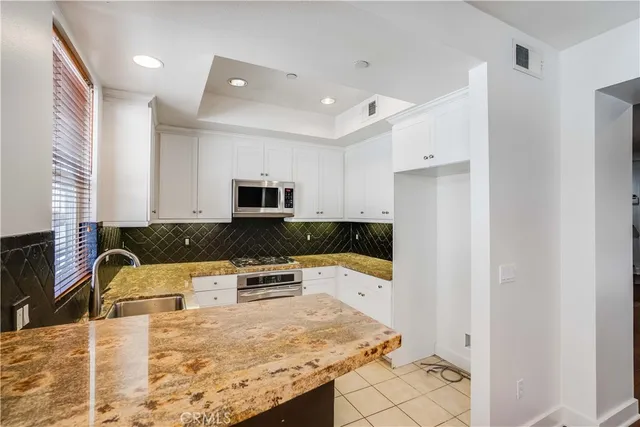 a kitchen with stainless steel appliances granite countertop a sink and a stove