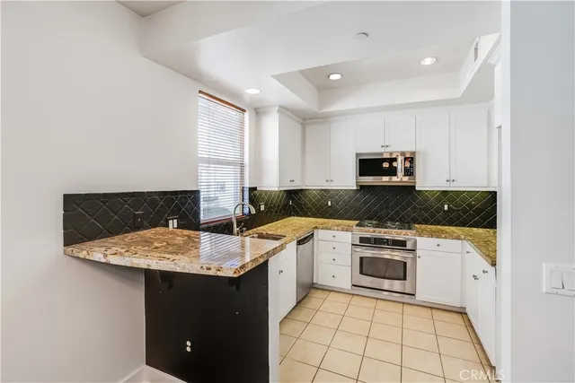 a kitchen with a sink stove and white cabinets