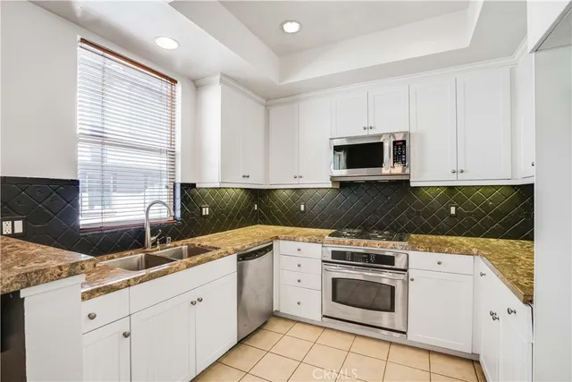 a kitchen with granite countertop white cabinets and white appliances