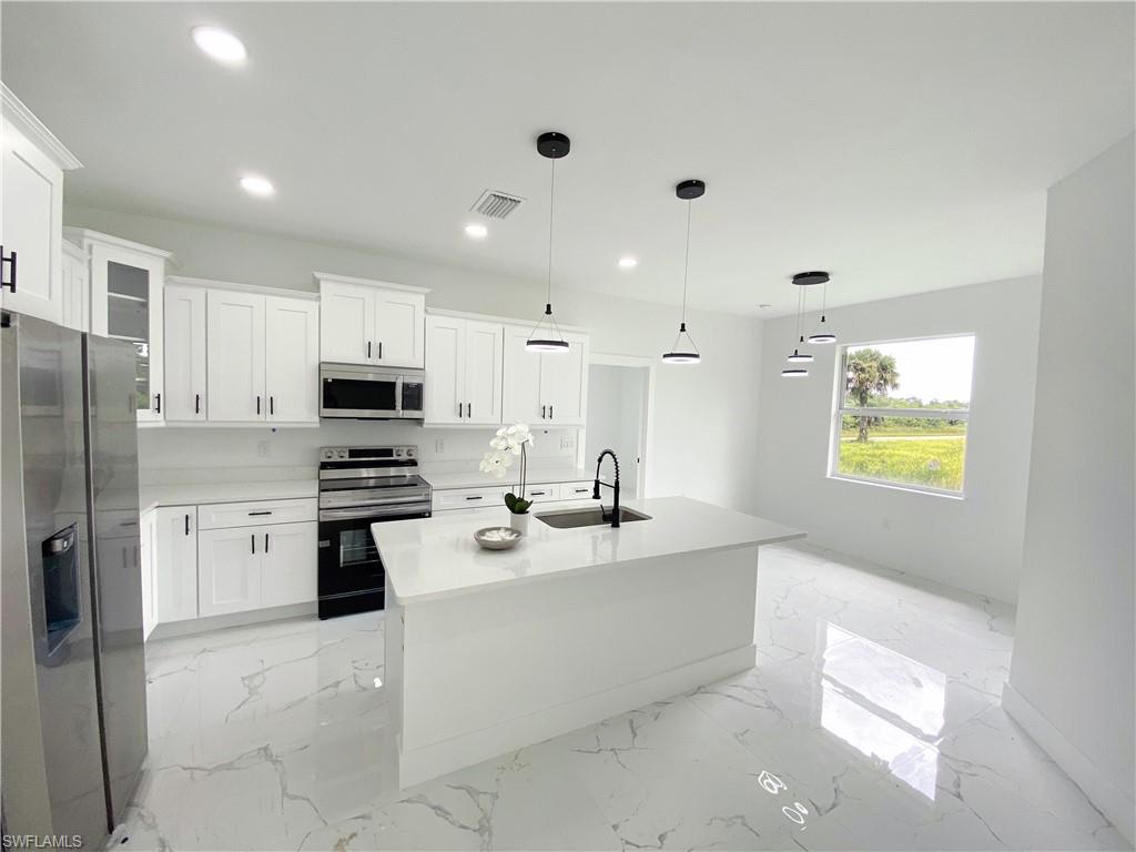 241 Novia Lehigh Acres, FL 33974 - Photo 12 of 28 a kitchen with stainless steel appliances a refrigerator sink and stove
