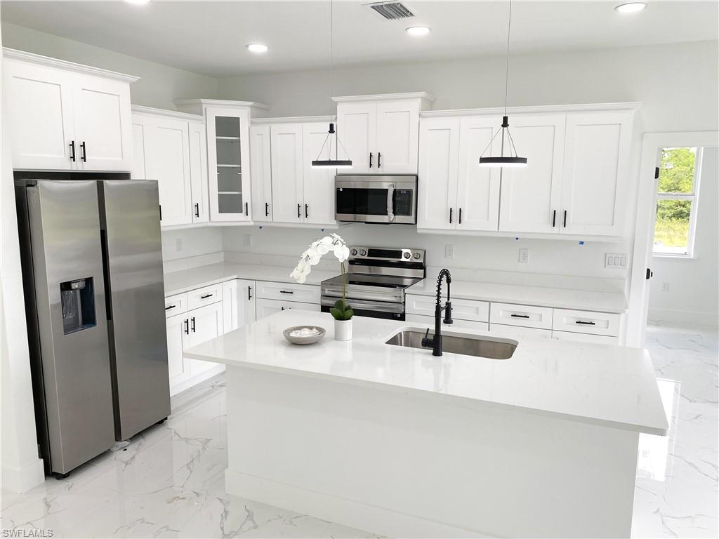 241 Novia Lehigh Acres, FL 33974 - Photo 15 of 28 a kitchen with stainless steel appliances a refrigerator stove top oven and sink