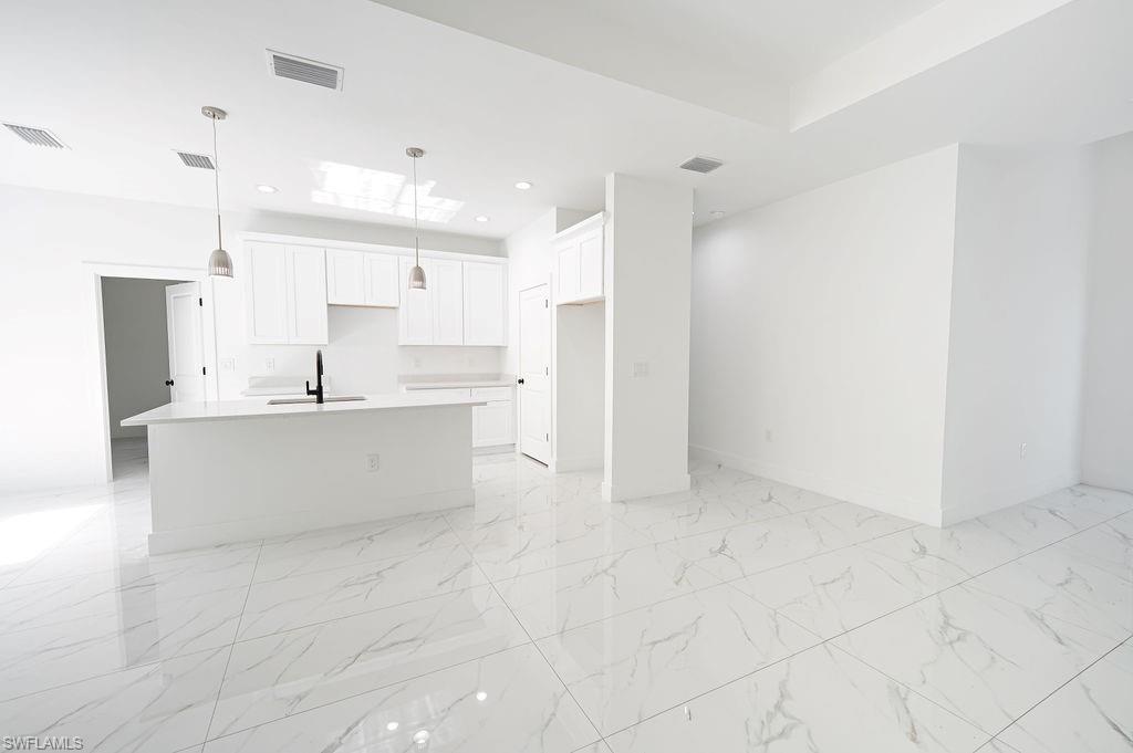 241 Novia Lehigh Acres, FL 33974 - Photo 17 of 28 a view of kitchen with kitchen island white cabinets and stainless steel appliances