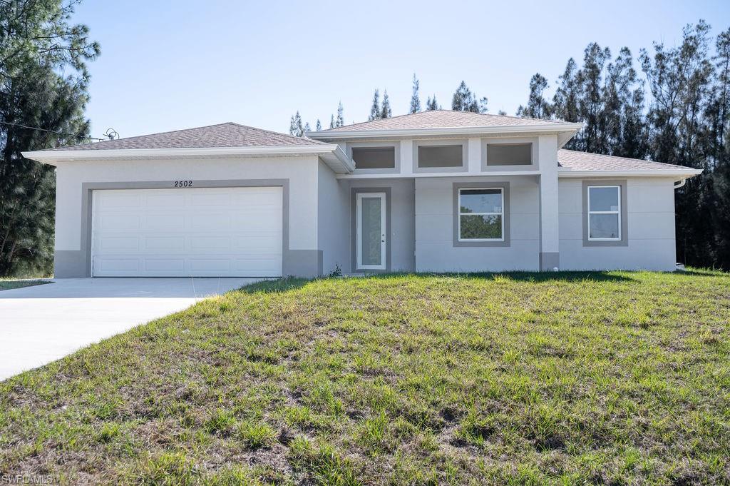 241 Novia Lehigh Acres, FL 33974 - Photo 25 of 28 a front view of a house with a yard and garage