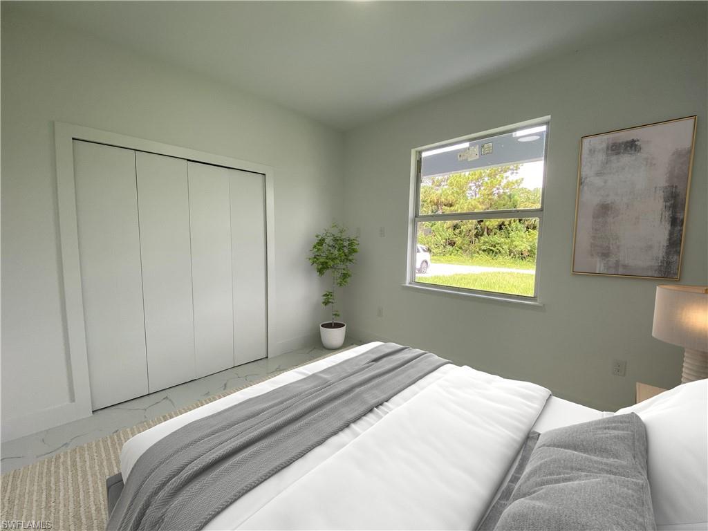 241 Novia Lehigh Acres, FL 33974 - Photo 5 of 28 a bedroom with a bed and a window