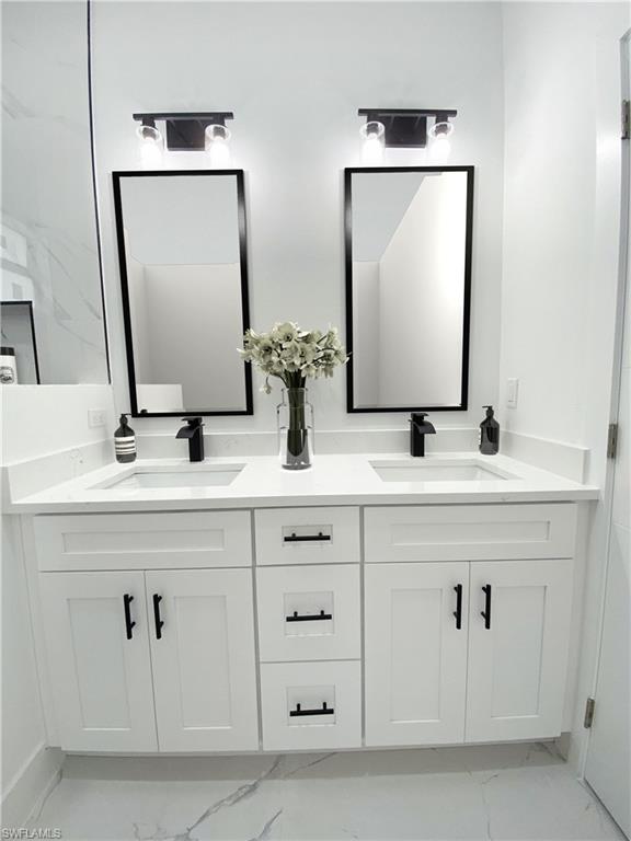 241 Novia Lehigh Acres, FL 33974 - Photo 6 of 28 a bathroom with double vanity sink and a mirror