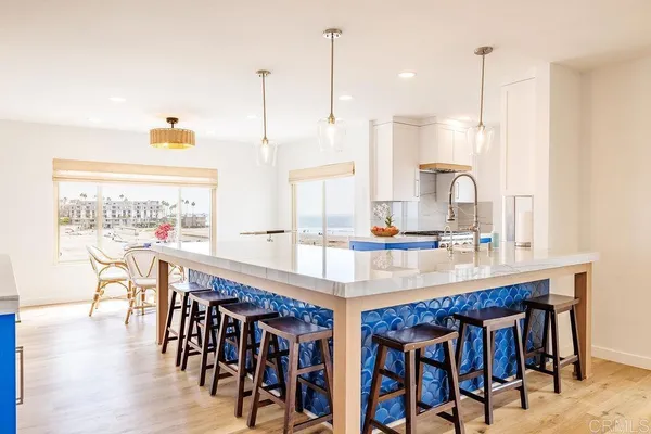 a dining table with chairs and kitchen view