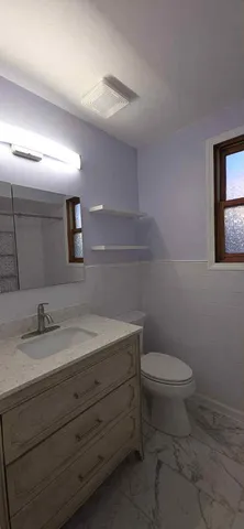 a bathroom with a granite countertop toilet and sink