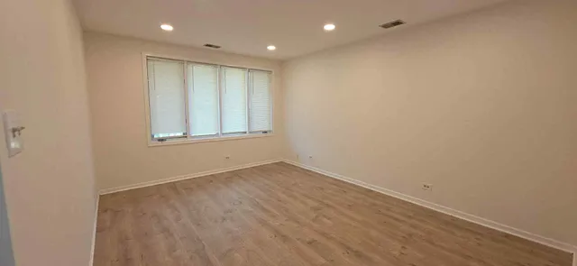 an empty room with wooden floor and window