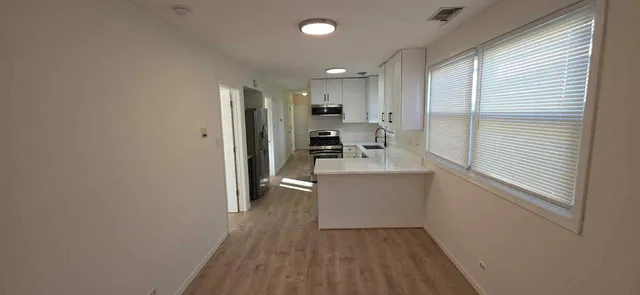 a kitchen with a refrigerator and white cabinets