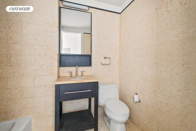 a view of a hallway with wooden floor and a bathroom