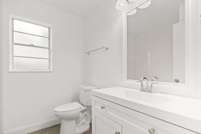 a bathroom with a sink toilet and a mirror
