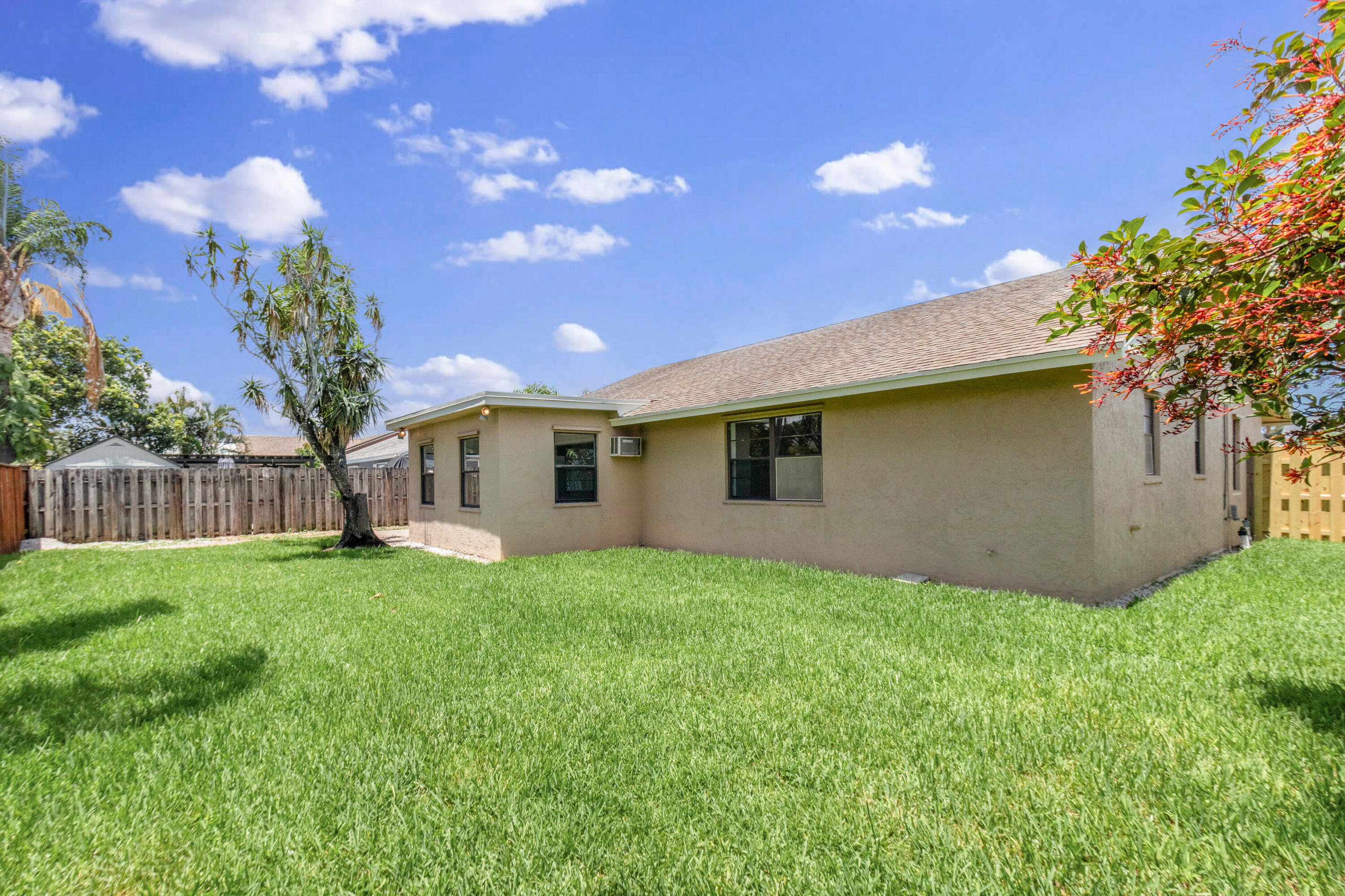 23089 Southwest 55th Avenue Boca Raton, FL 33433 - Photo 21 of 29 a view of a yard with plants and a large tree