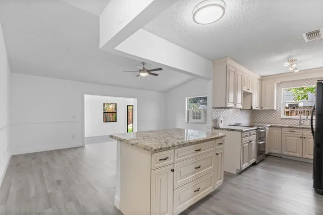 a kitchen with granite countertop a sink cabinets and wooden floor