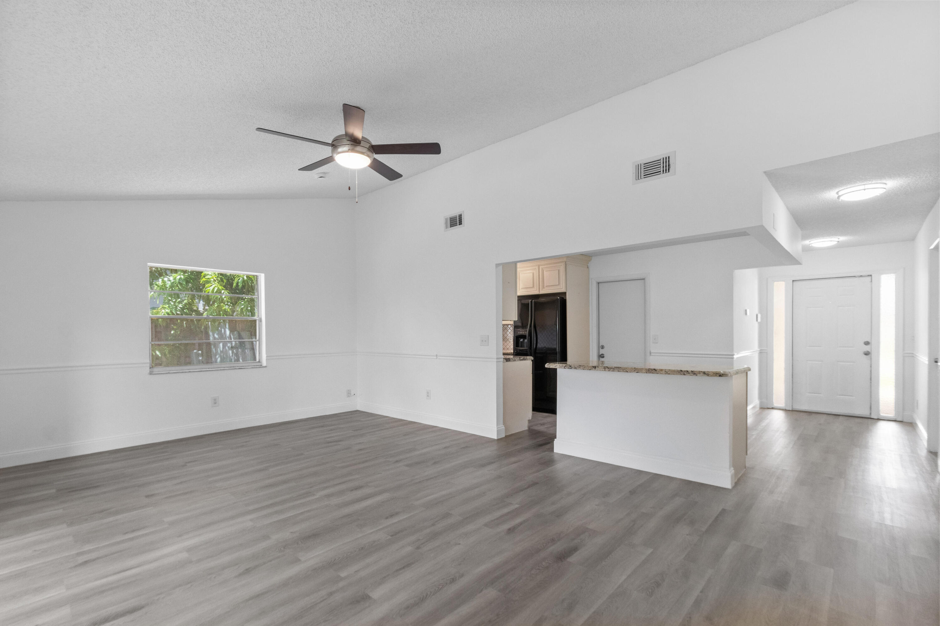 23089 Southwest 55th Avenue Boca Raton, FL 33433 - Photo 5 of 29 a view of empty room with wooden floor and window
