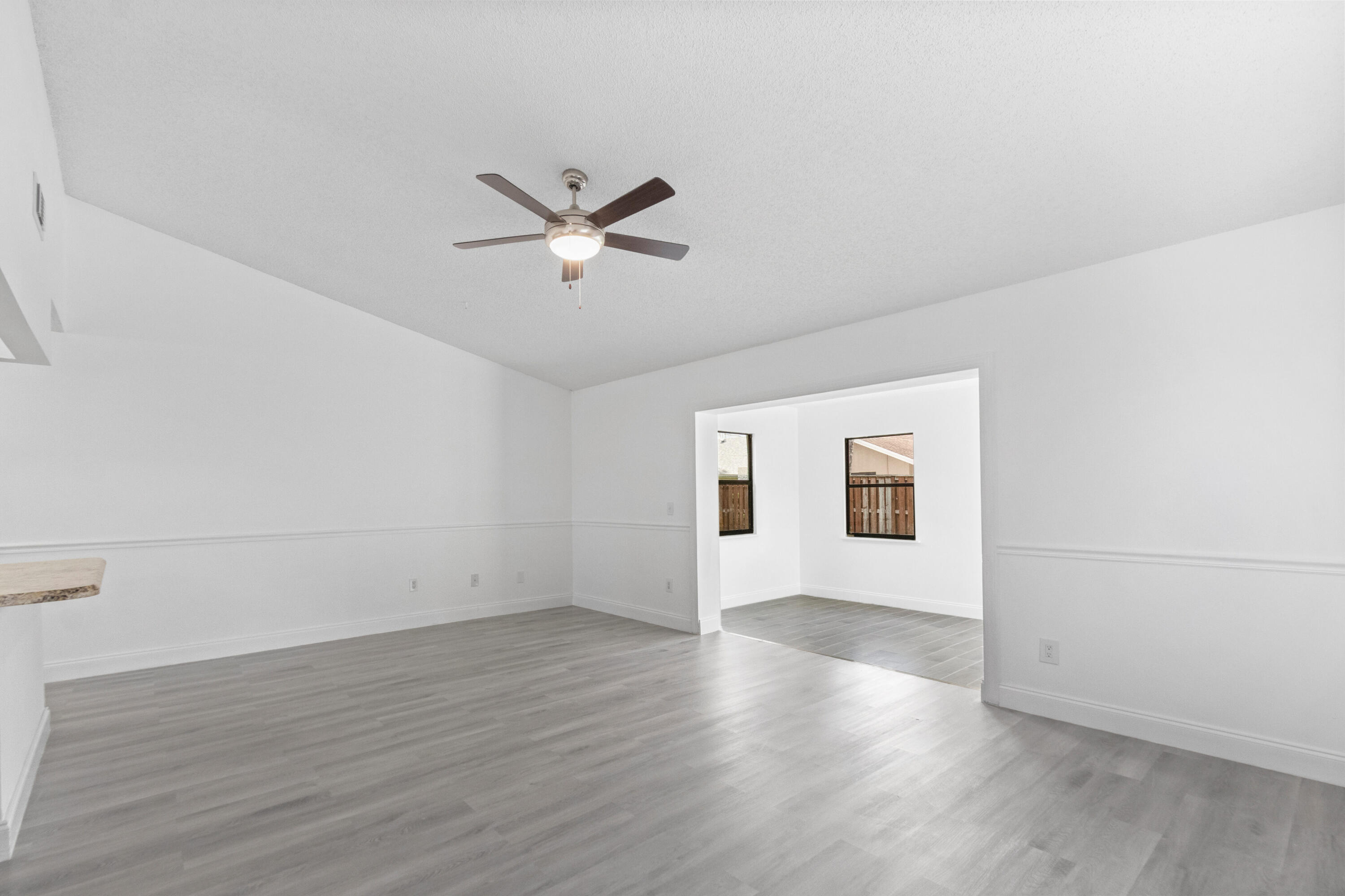 23089 Southwest 55th Avenue Boca Raton, FL 33433 - Photo 6 of 29 an empty room with wooden floor and windows