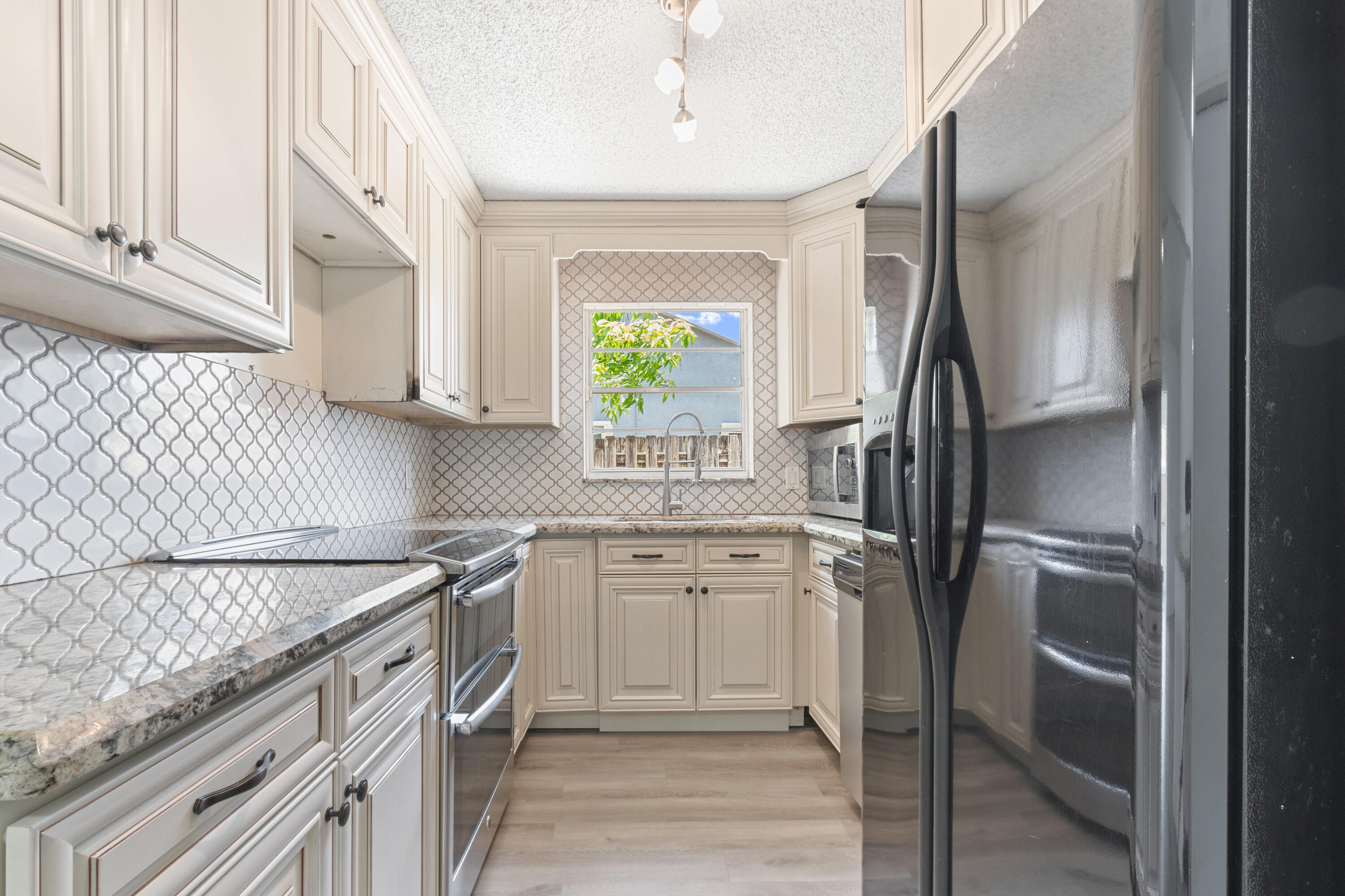 23089 Southwest 55th Avenue Boca Raton, FL 33433 - Photo 9 of 29 a kitchen with a sink appliances and cabinets