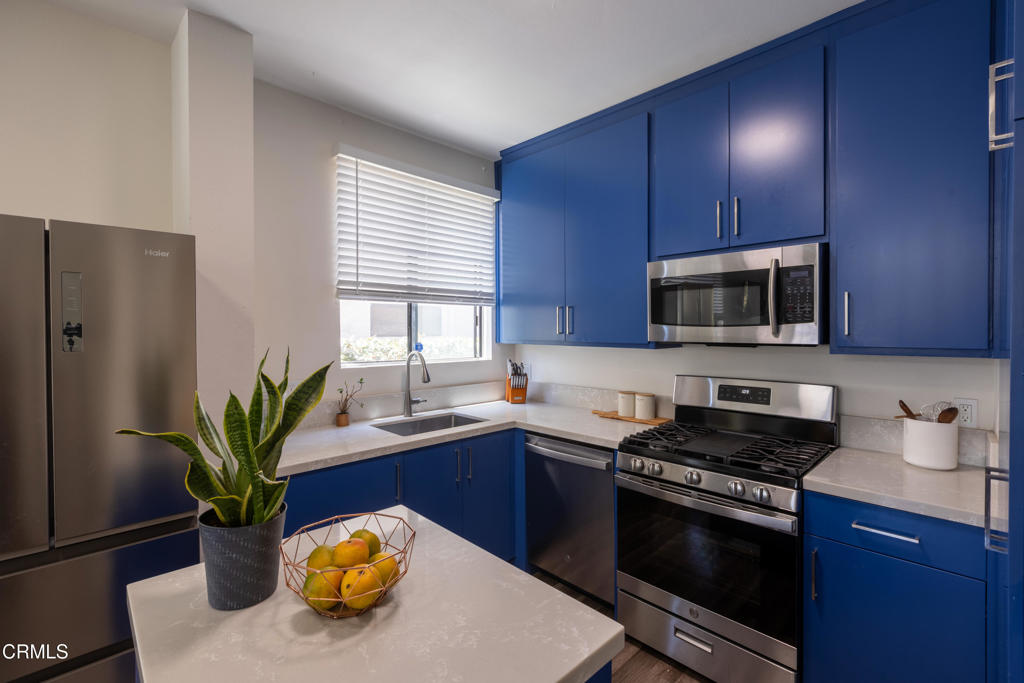 12007 Rochester Avenue, Unit 1 Los Angeles, CA 90025 - Photo 16 of 32 a kitchen with stainless steel appliances a sink a microwave a refrigerator a stove and a window