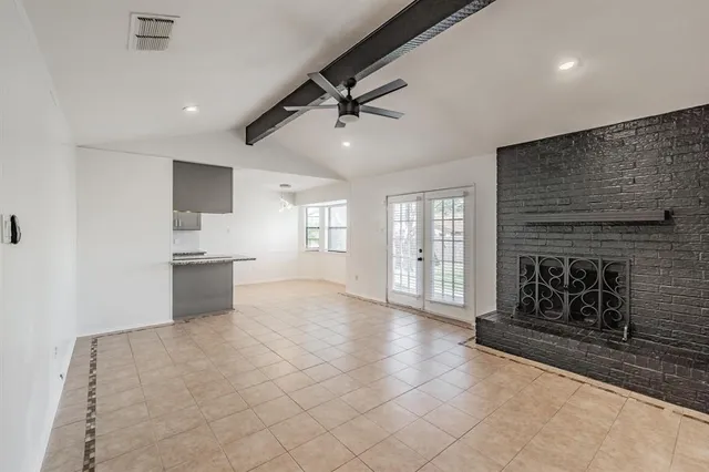 an empty room with windows and fireplace