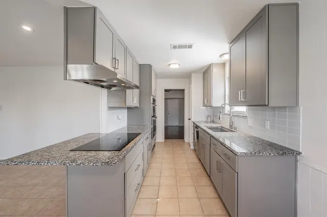 a kitchen with stainless steel appliances granite countertop a sink and a stove