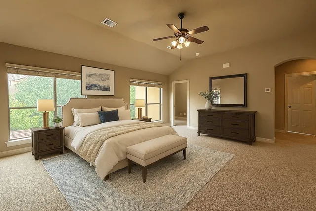 a spacious bedroom with a bed a couch and large window