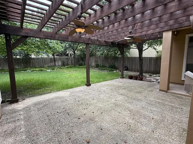 a view of a backyard with a large tree and wooden fence