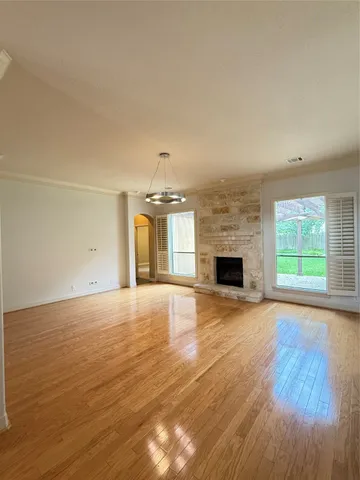 an empty room with wooden floor and fireplace