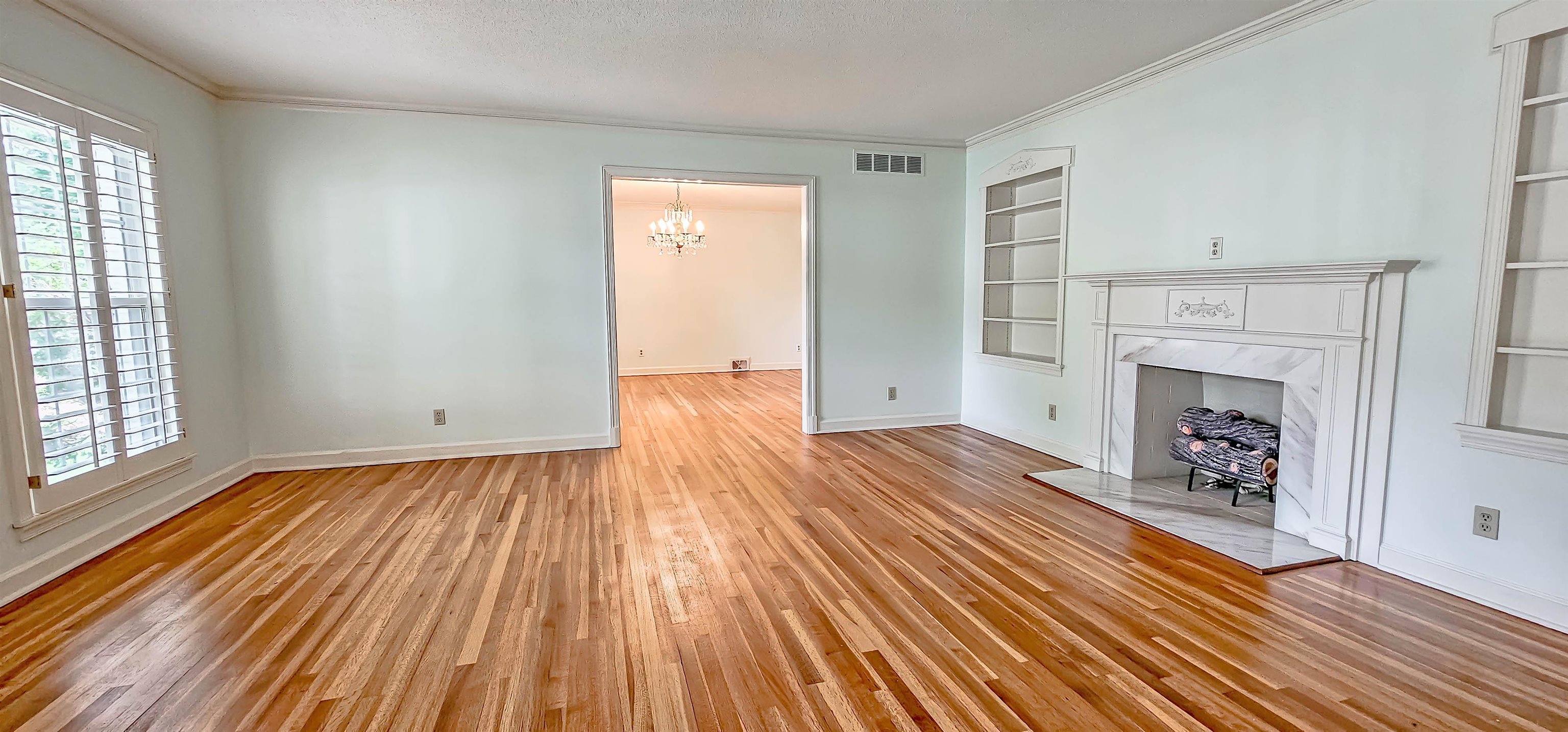 154 Perkins Extension Memphis, TN 38117 - Photo 5 of 40 an empty room with wooden floor a fireplace and windows