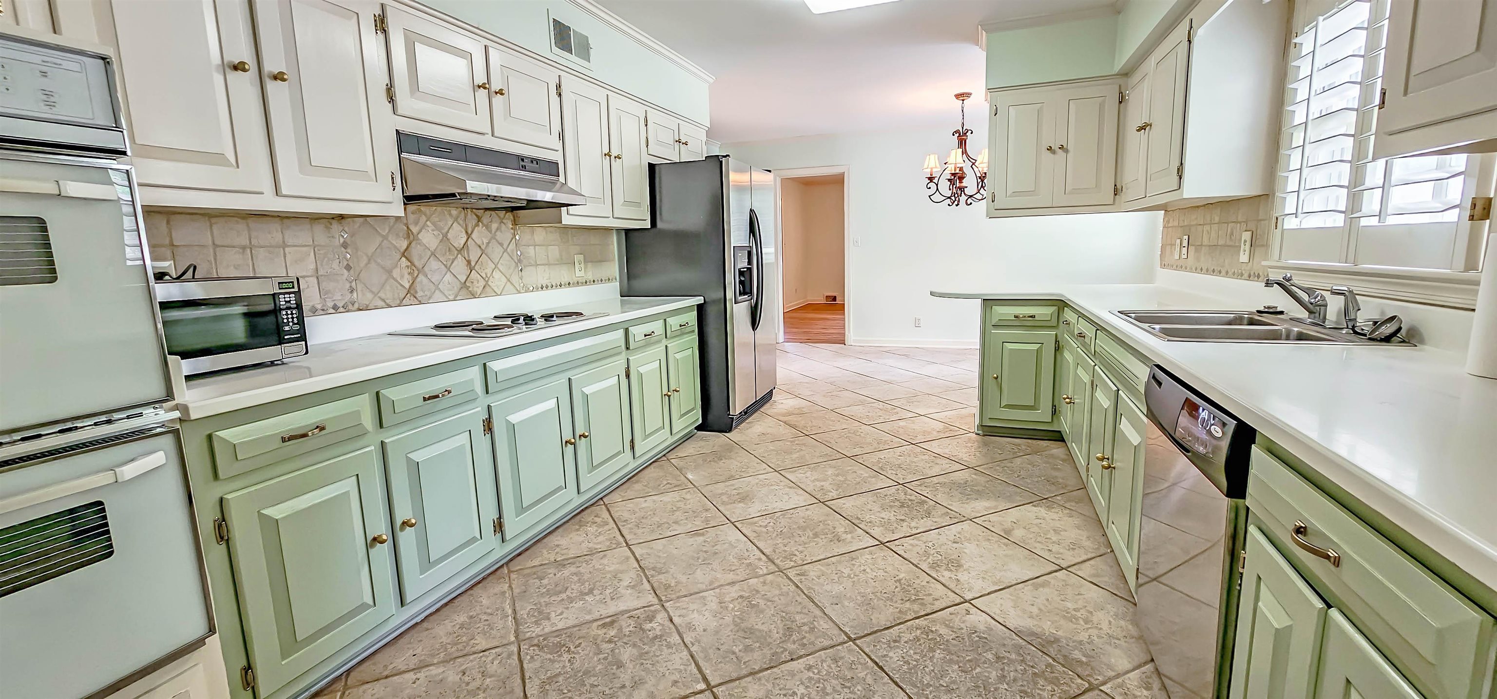 154 Perkins Extension Memphis, TN 38117 - Photo 10 of 40 a kitchen with stainless steel appliances cabinets a sink and a stove