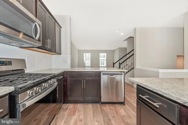 a kitchen with stainless steel appliances granite countertop a stove microwave and sink