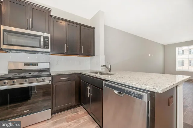 a kitchen with stainless steel appliances granite countertop a stove microwave and refrigerator