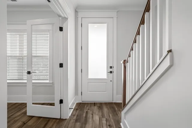 a view of a hallway with wooden floor and staircase