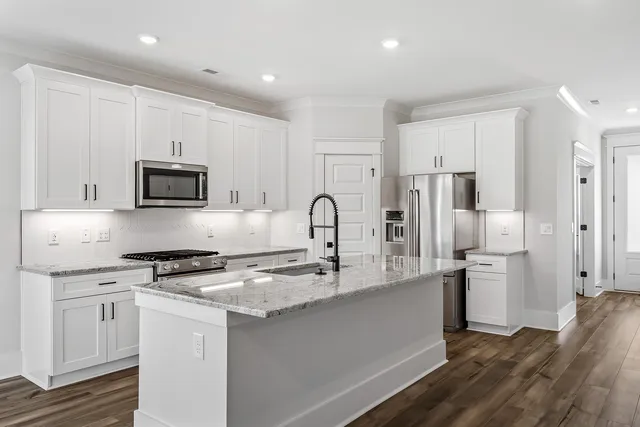 a kitchen with stainless steel appliances granite countertop a refrigerator and a stove top oven