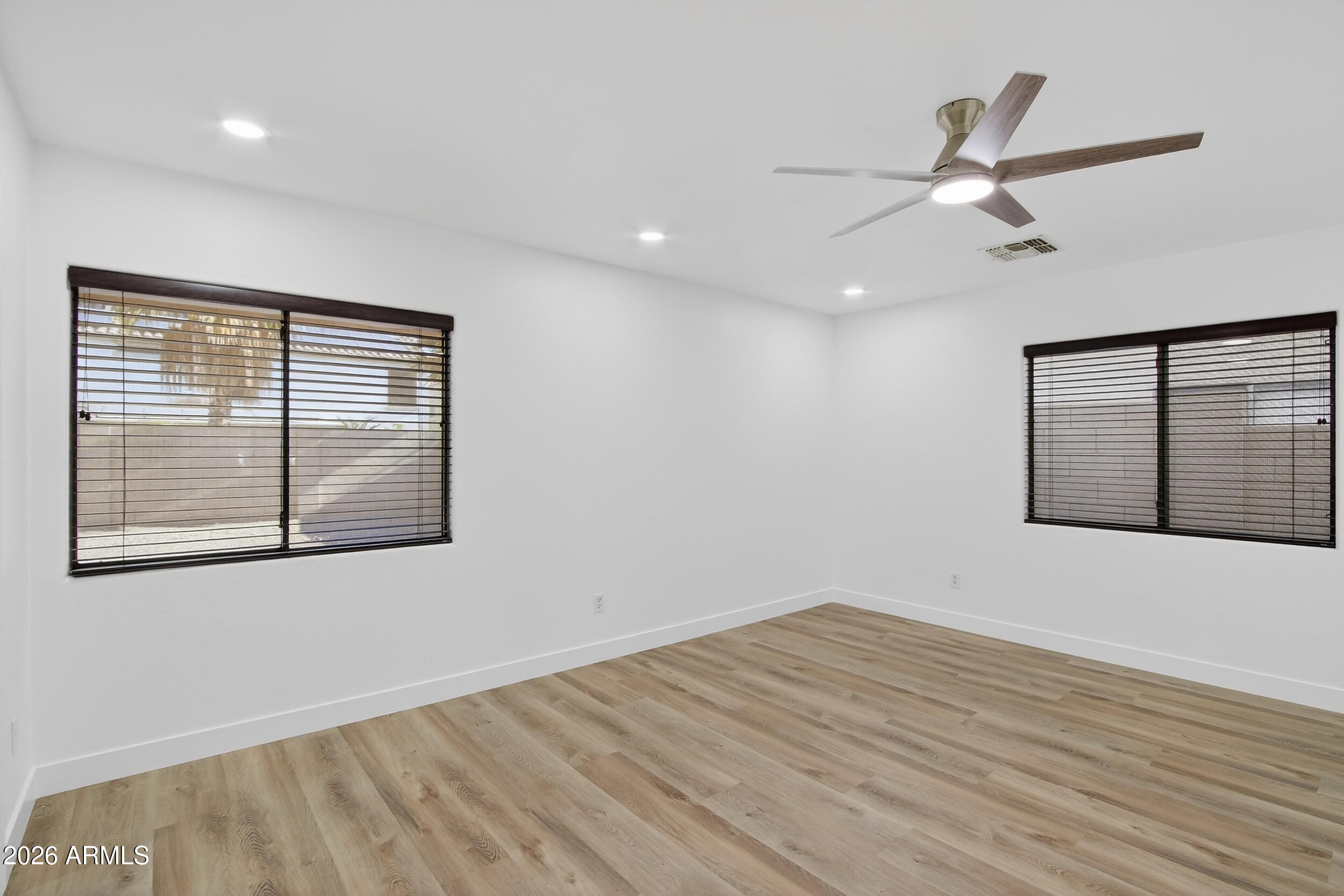 43620 West Cowpath Road Maricopa, AZ 85138 - Photo 9 of 60 a view of an empty room with wooden floor and a window