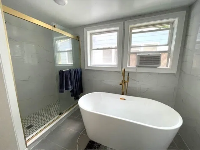 a white bath tub sitting in a bathroom next to a window