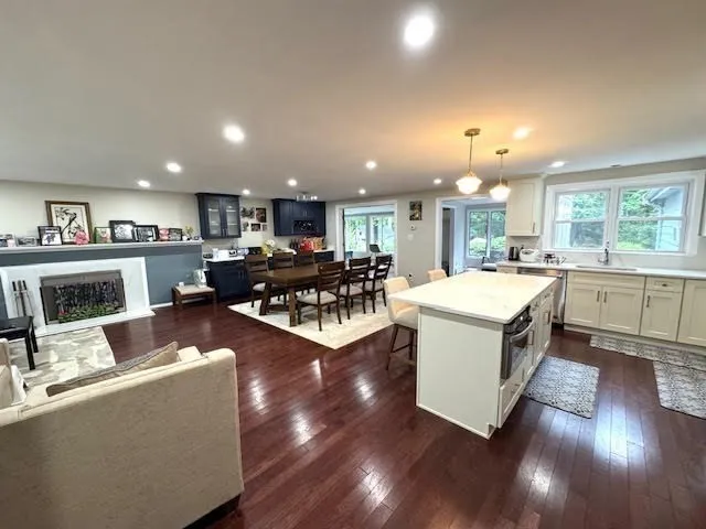 a living room with furniture a kitchen view and a fireplace