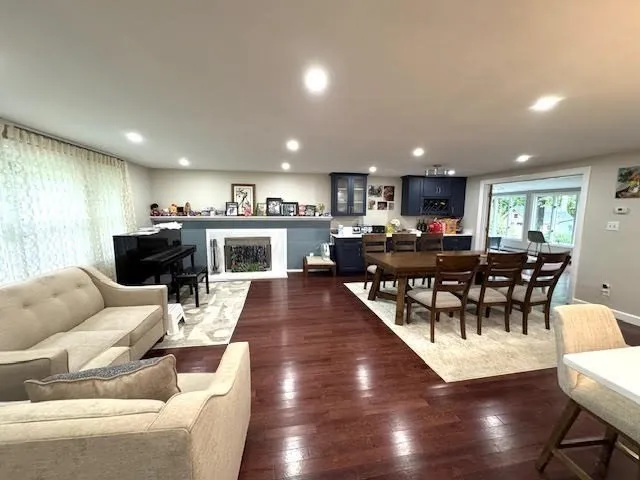 a living room with furniture kitchen view and a large window