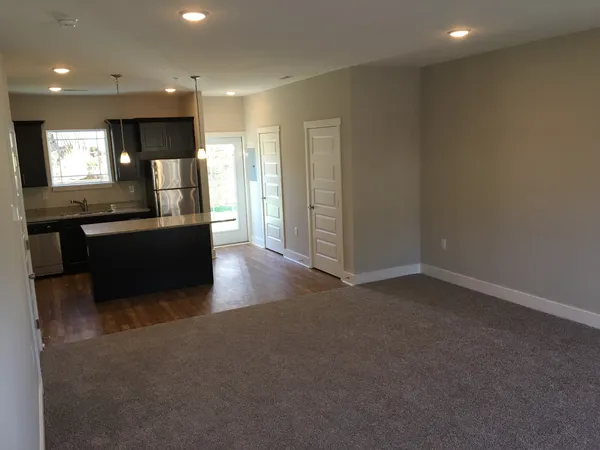 a view of kitchen with stainless steel appliances granite countertop a refrigerator a sink a stove and a microwave