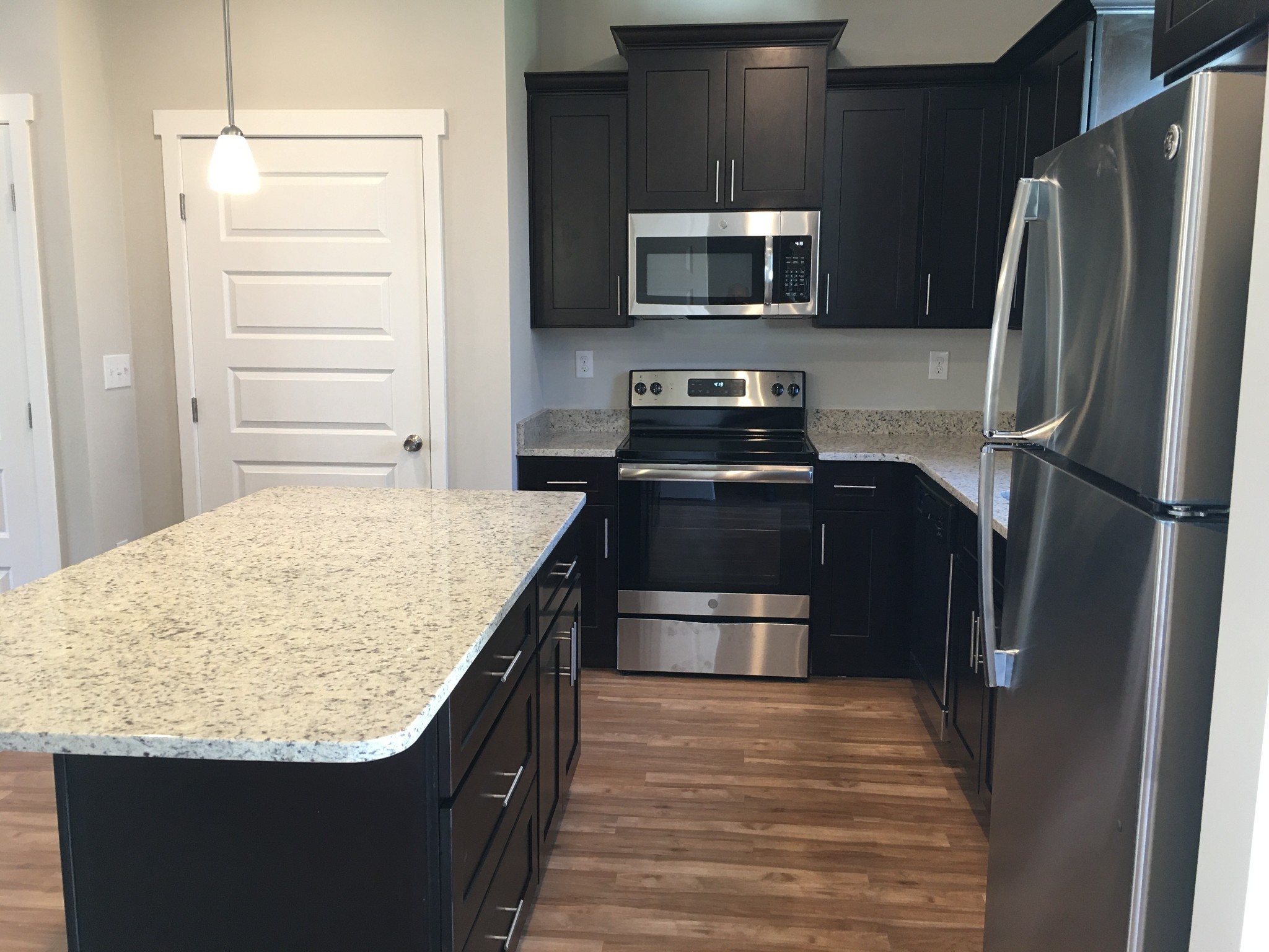 7006 Magnolia Crossings Spring Hill, TN 37174 - Photo 5 of 18 a kitchen with kitchen island granite countertop stainless steel appliances and wooden cabinets