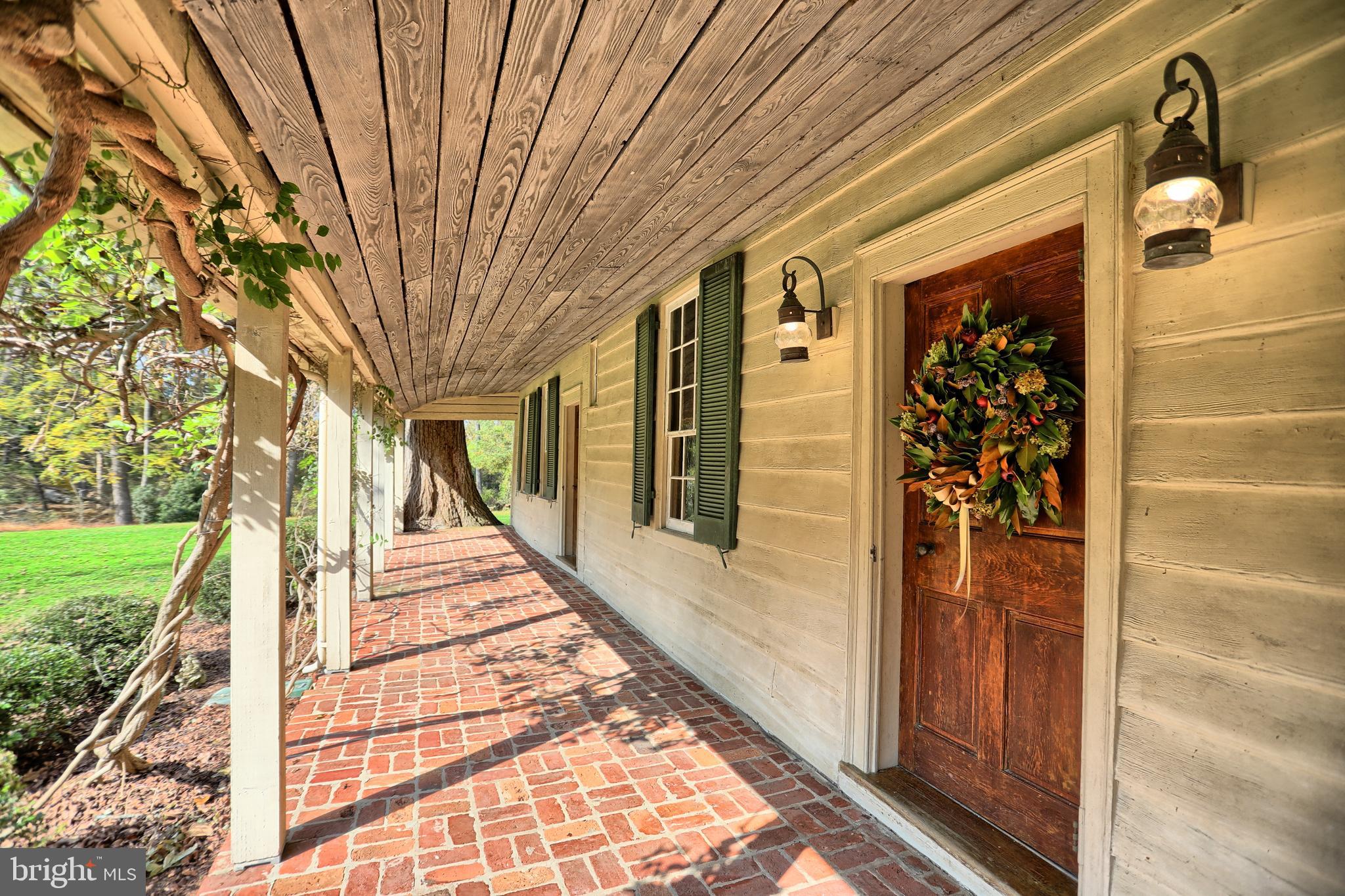 Sweeping front porch with late 19thc wisteria vine