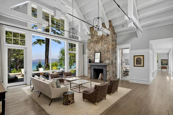 a living room with furniture large window and wooden floor