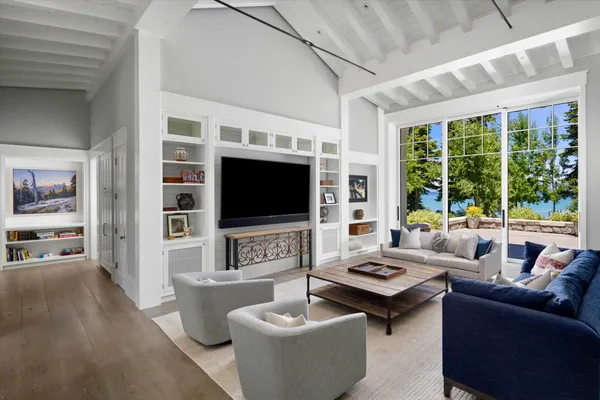 a living room with furniture a flat screen tv and a large window