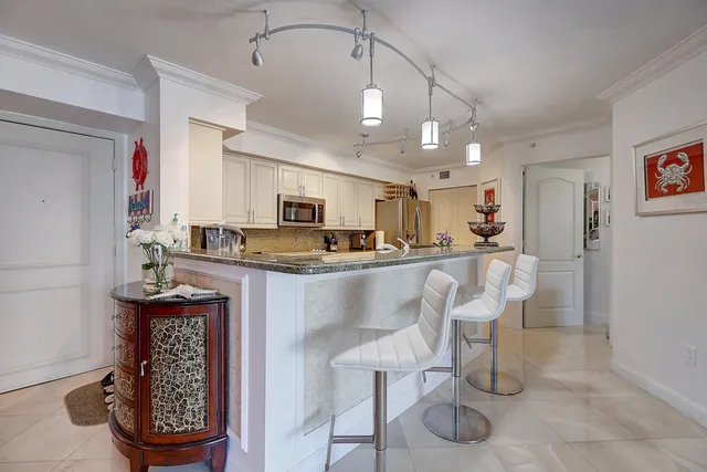 a kitchen with stainless steel appliances granite countertop white cabinets sink and a granite counter top
