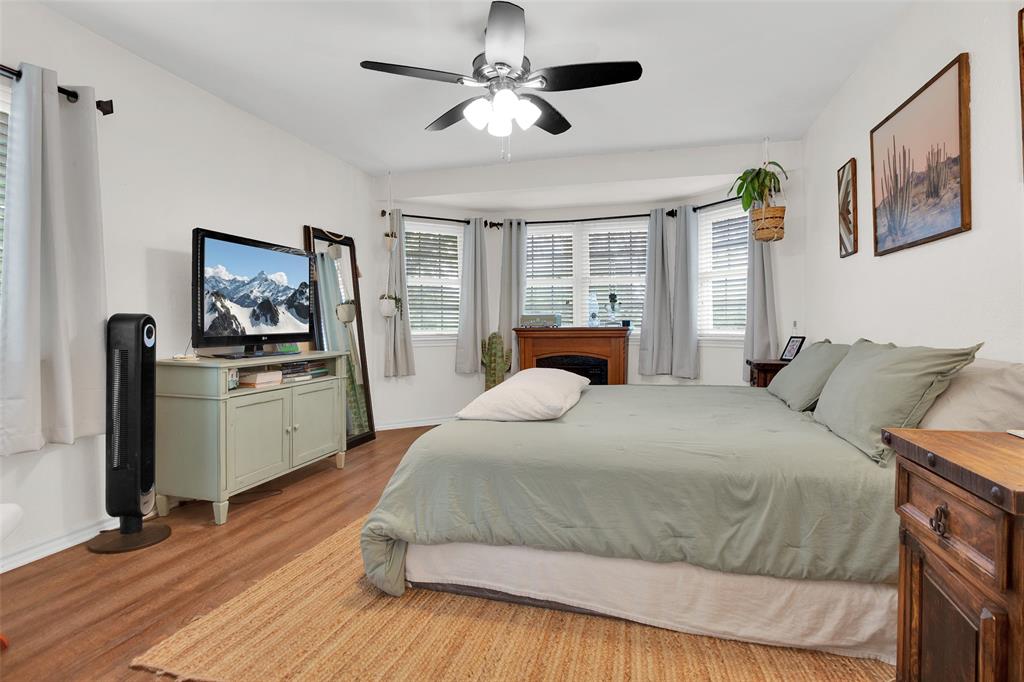 7634 Preston Road Denison, TX 75020 - Photo 14 of 34 a bedroom with a large bed and a chandelier