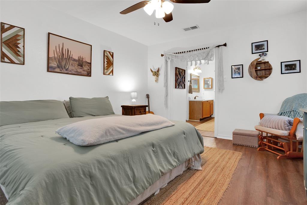 7634 Preston Road Denison, TX 75020 - Photo 15 of 34 a bedroom with a bed and wooden floor